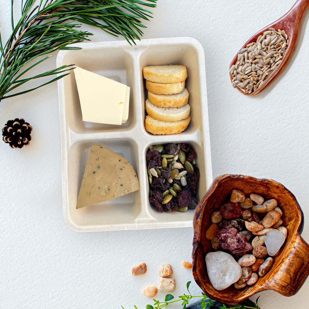 Open tray of C’est La Ve vegan Peppered charcuterie Luncherie snack, including black pepper deli slices, Provolone slices, bruschetta, and nut free trail mix.